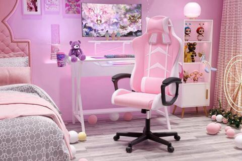 Cadeira gamer feminina rosa em espaço moderno com mesa branca e decoração temática, ideal para setup de jogos ou home office.